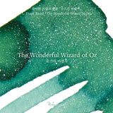 A vivid emerald green is infused with mysterious silver and blue shimmer, weaving through the surface with an ethereal glow and capturing the fantastical journey toward the Emerald City.