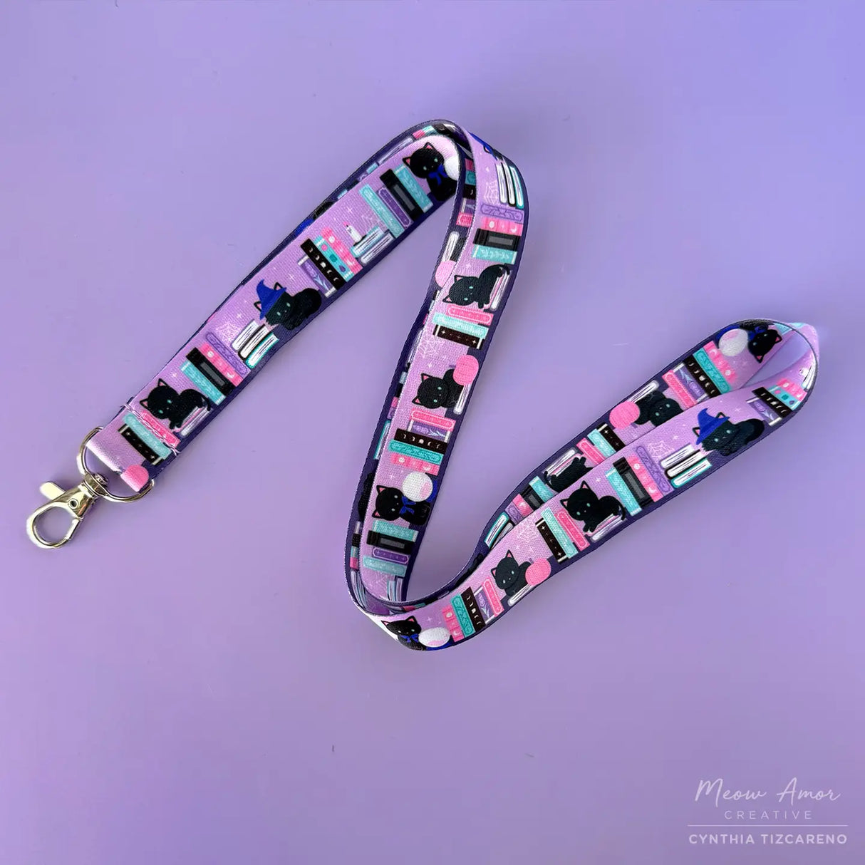 Bookish Witch Cat Lanyard. This purple lanyard features witch cats and books, perfect for all cat lovers out there. Show off your love for felines while keeping your items secure and easily accessible.

2cm X 95cm
double-sided printing
Swiveling Lobster Clasp
