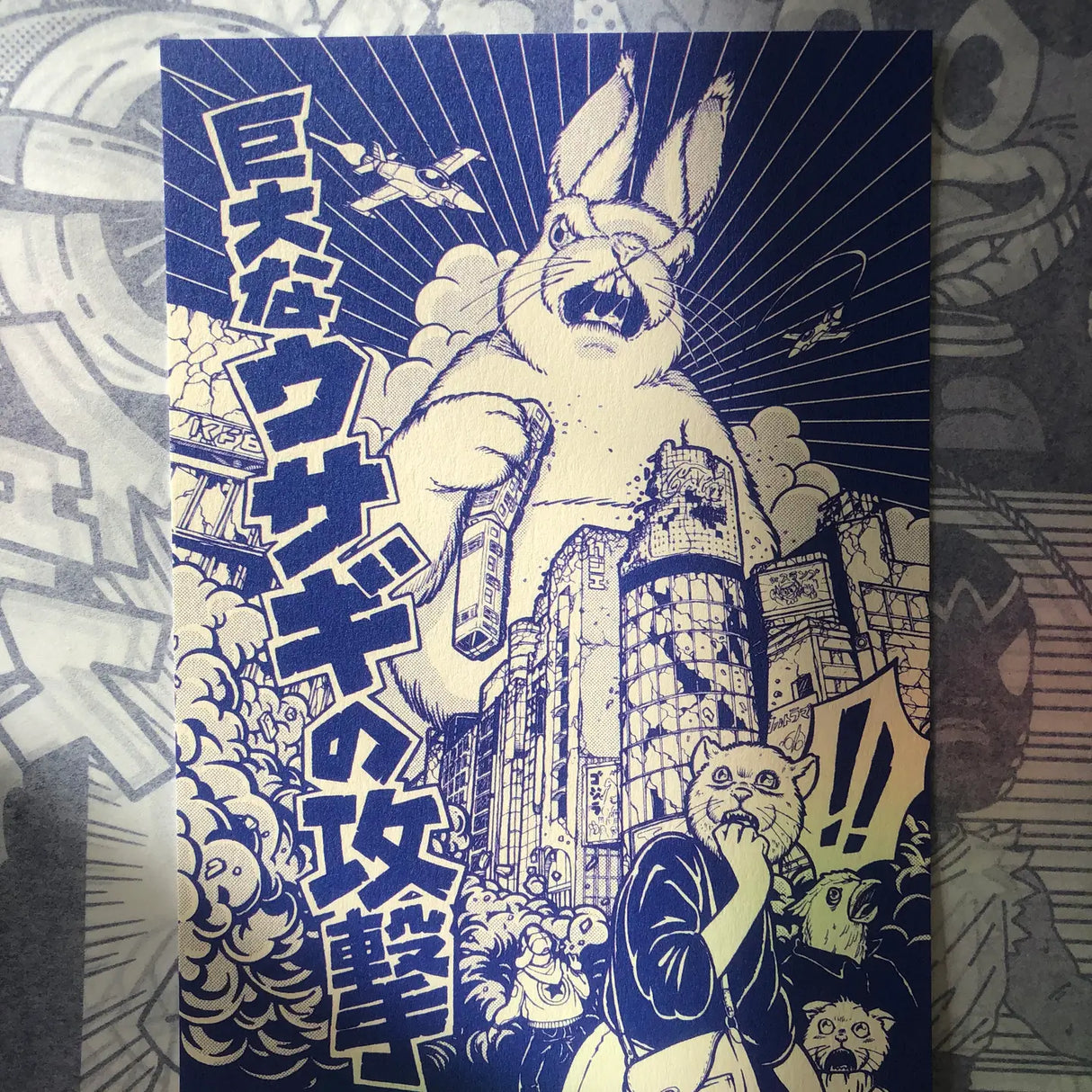 This illustration is inspired by Kaiju Eiga (giant Japanese monster movies) and more specifically by some posters from the first Godzilla movies. It represents a giant rabbit attacking the Ginza neighborhood in Tokyo, Japan. Translation Kyodaina Usagi no Kōgeki: Attack of the Giant Rabbit

• Postcard format A6 (14.8 x 10.5cm)
• Fedrigoni Arena 300gm2 FSC certified paper
• printed in France