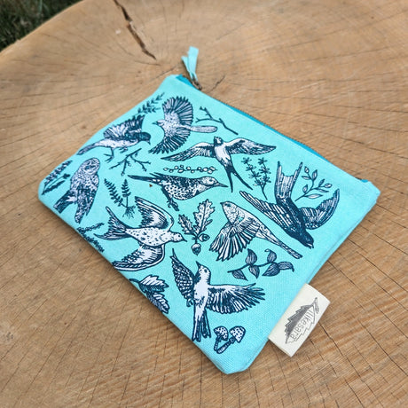 Take some feathered friends everywhere you go with this canvas bird zippered pouch. Featuring bird illustrations by ilikesara (aka Sara Schalliol-Hodge) combined with botanicals, this handy zippered pouch will keep you organized (in flight or on land!). Great for storing snacks, pencils, bird seed, your feather collection, etc. The water-resistant inner layer is not only wipeable but adds structure to the bag.